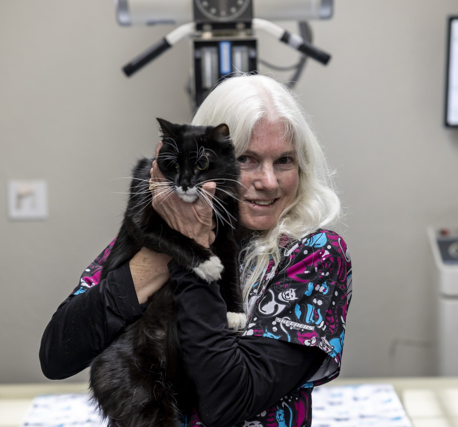 Staff member holding black cat Staff member holding black cat